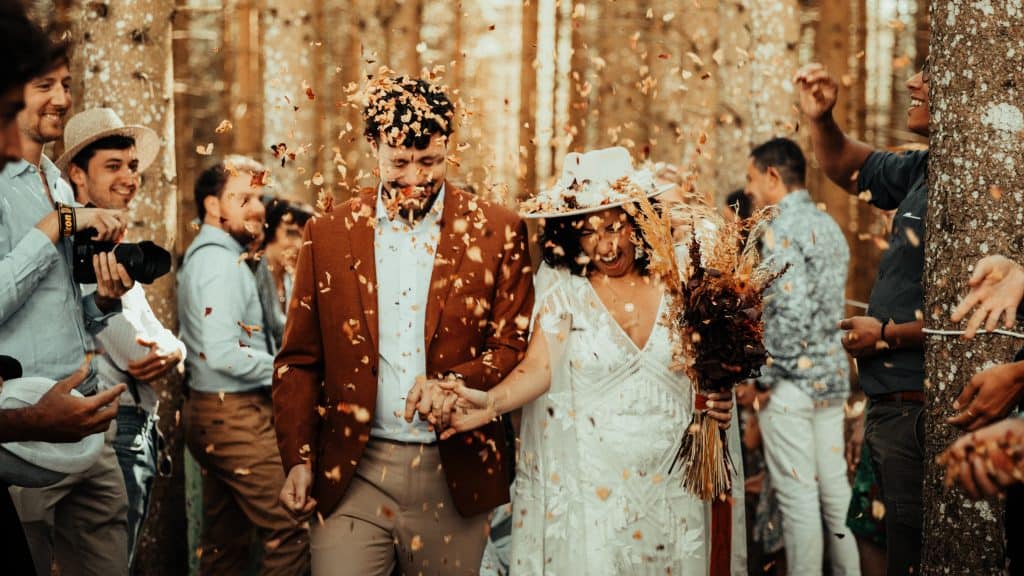 Picture of a LatinX bride and groom with their wedding guests and confetti