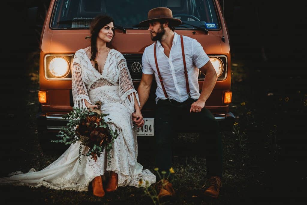 bride and groom in front of an orange VW van