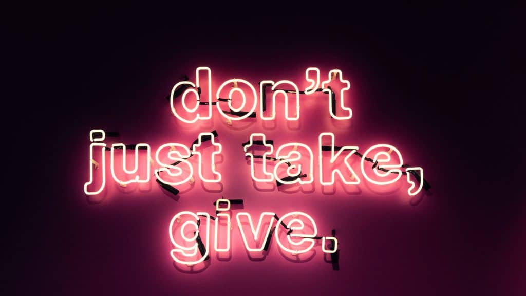 a pink neon sign that says "don't just take, give"