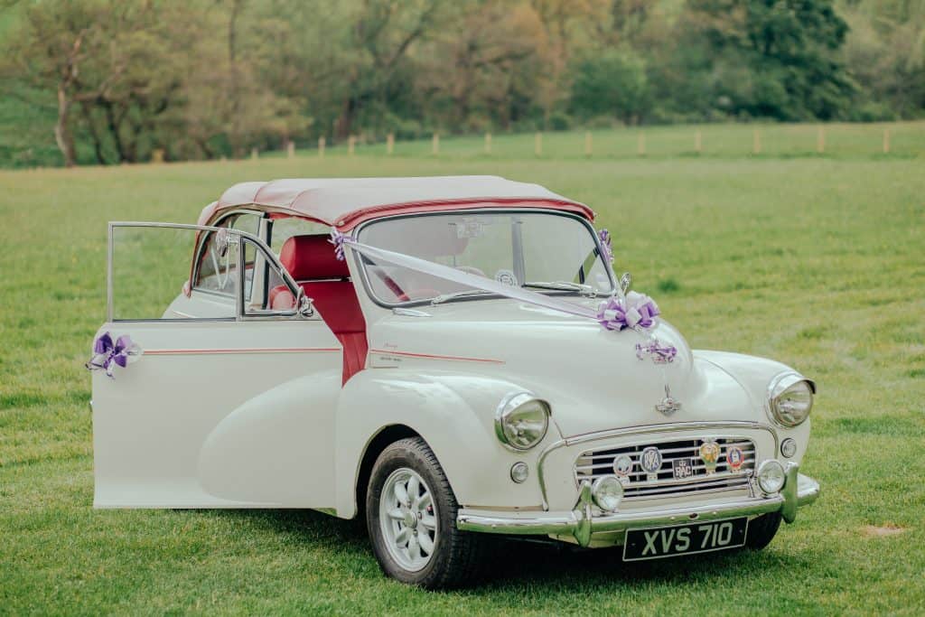 photo of a retro white car with flowers and ribbon