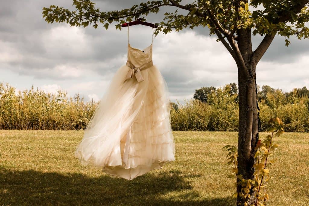 a wedding gown hanging to dry in a field