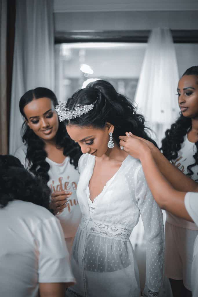 black woman in a wedding dress with all of her bridesmaids