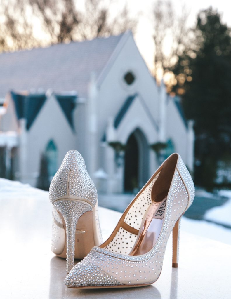 brides shoes in front of a chruch