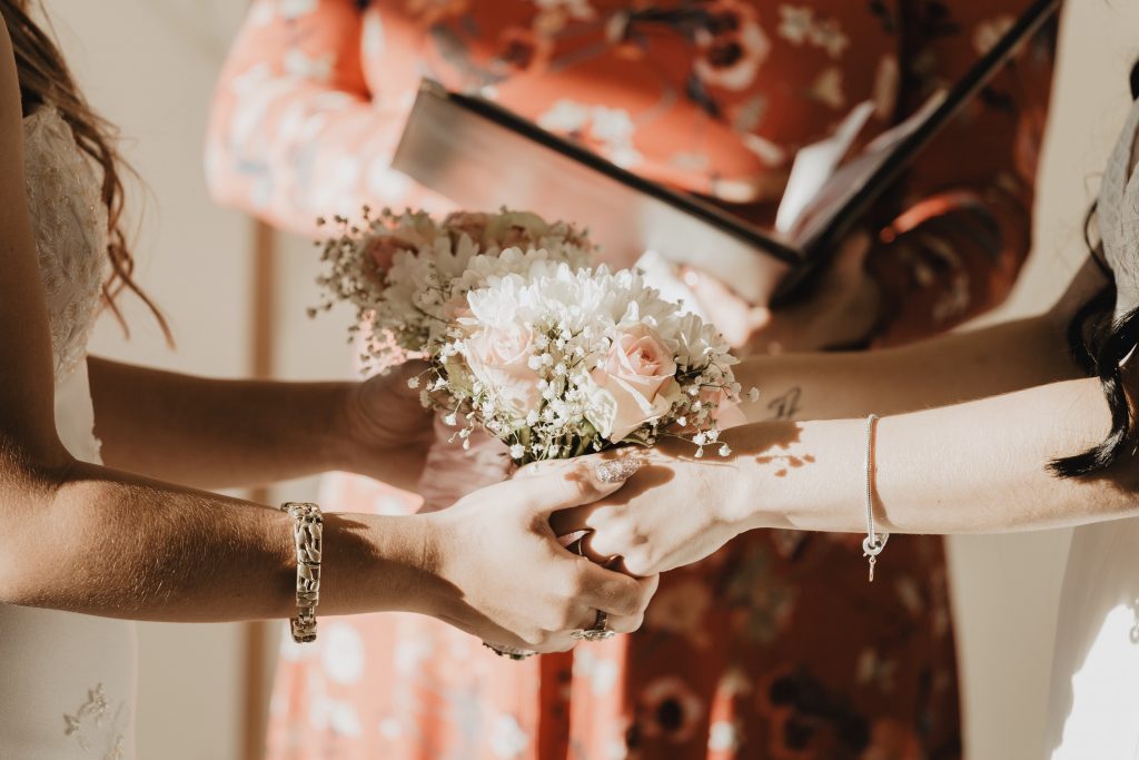 two brides saying i do and holding a bouquet