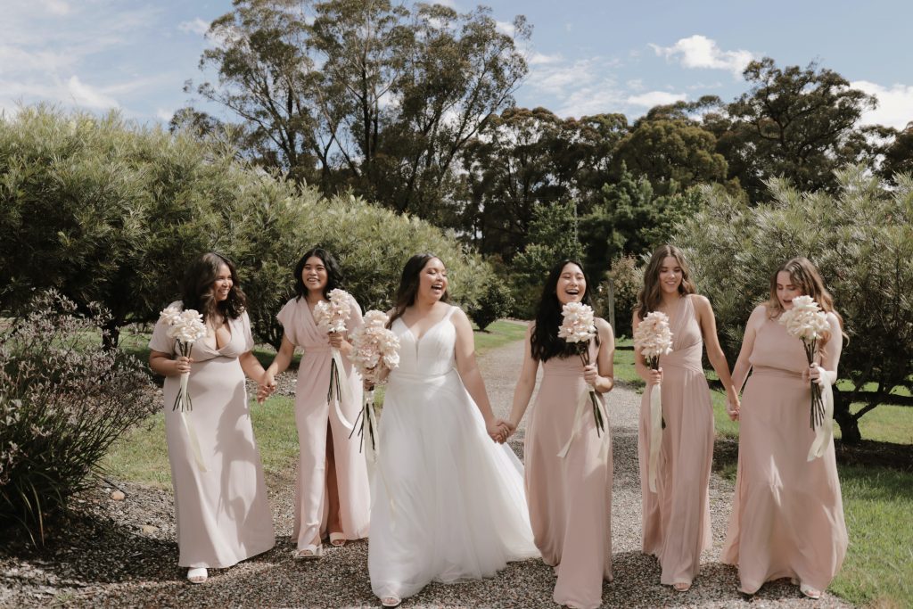 a bride laughing with her bridesmaids 