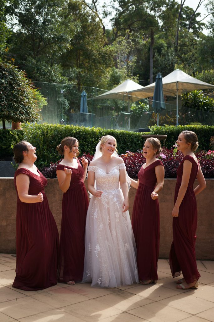 bride with her bridal party in burgundy dresses 