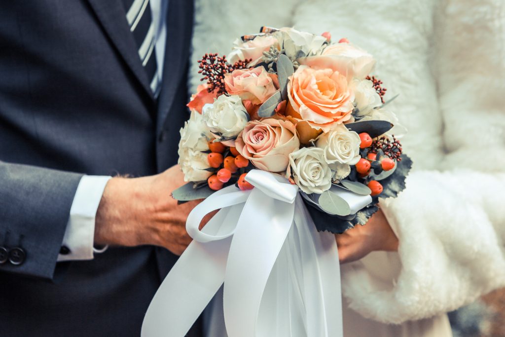 bride and groom holding a winter wedding bouquet
