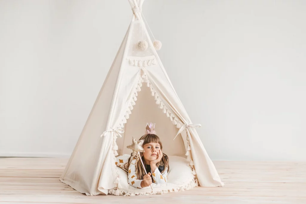 girl pretending to be a fairy princess inside of a white tent