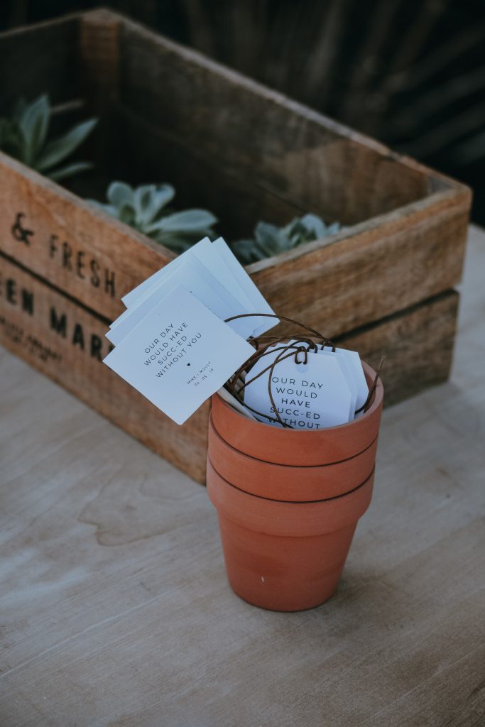 minature plant pot wedding favors that say "our day would have succ-ed without you"