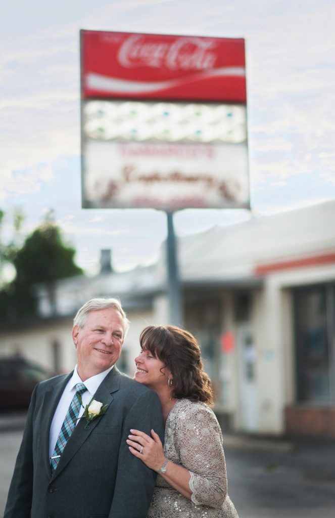 older bride and groom outside of a coca cola sign