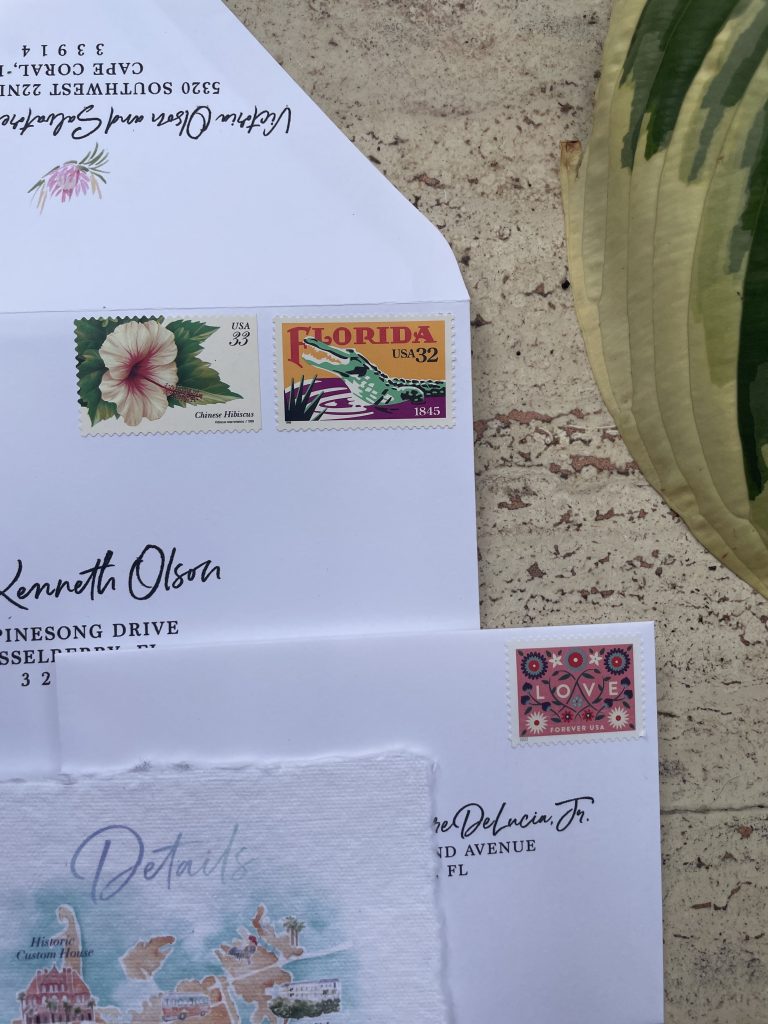 pile of envelopes with vintage stamps on a brown background with a tropical leaf