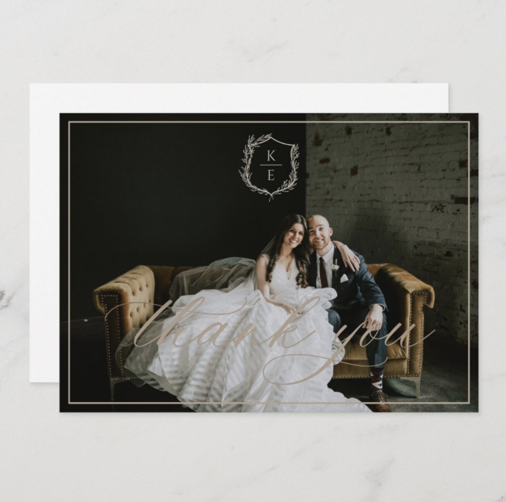 thank you card with a picture of bride and groom and wedding crest on a grey marble background