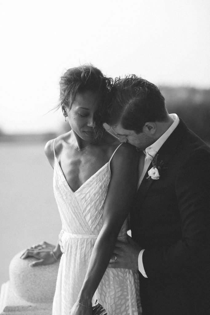 black and white photo of a bride and groom embracing in the wind