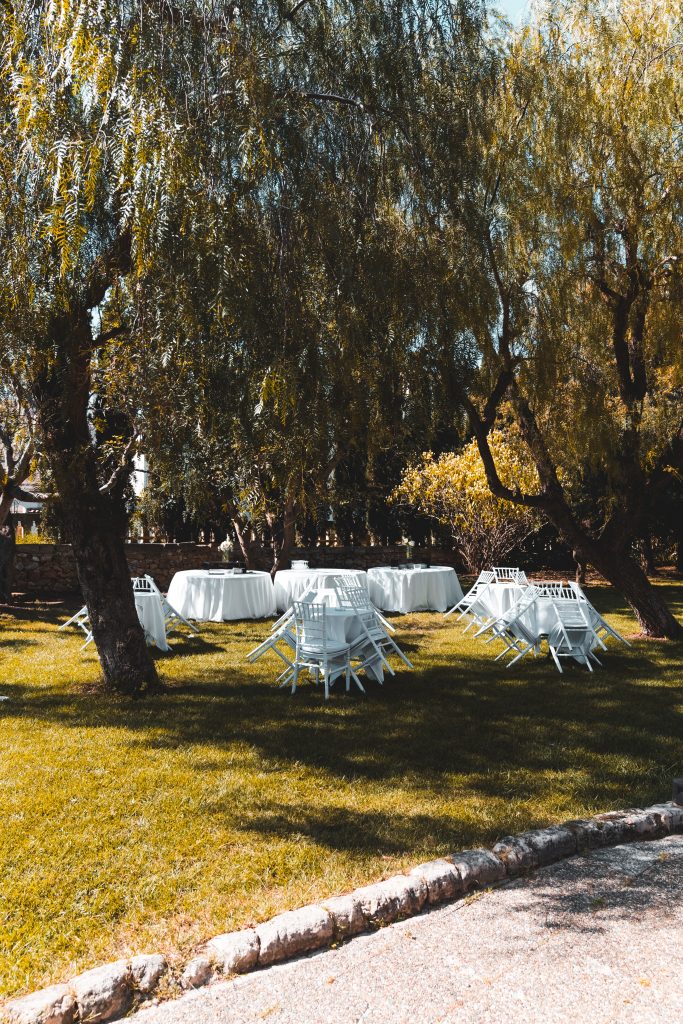 white tables and chairs set up in a backyard