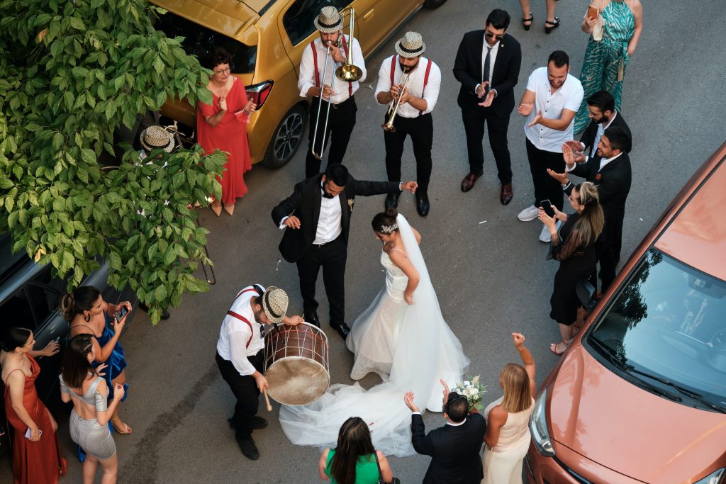 bride and groom dancing in the street with a band playing