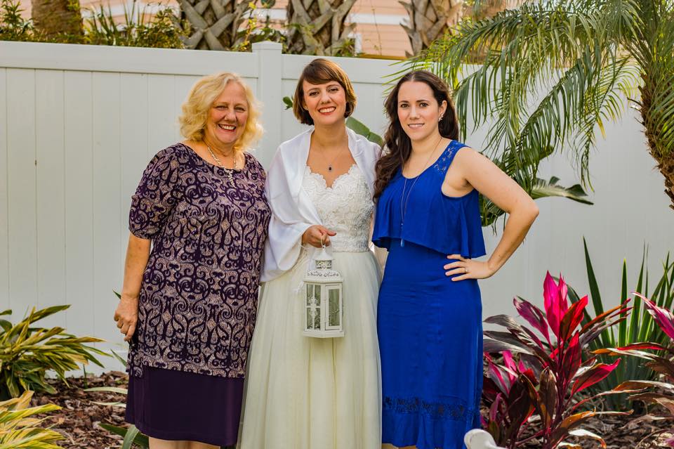 photo of a bride, bridesmaid and mother in a tropical backyard wedding
