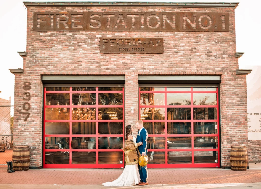 bride and groom in front of a firehouse